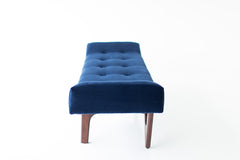 Angled view of the modern luxury Alaska bench highlighting its hand-shaped walnut legs by Craft Associates