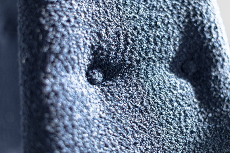 Close-up of the modern luxury Alto dining chair's upholstery and solid walnut frame joinery by Craft Associates