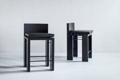 Chunky modern counter stool in black leather with black metal legs
