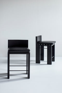 Detail of the oak wood grain and metal joinery on a black stool