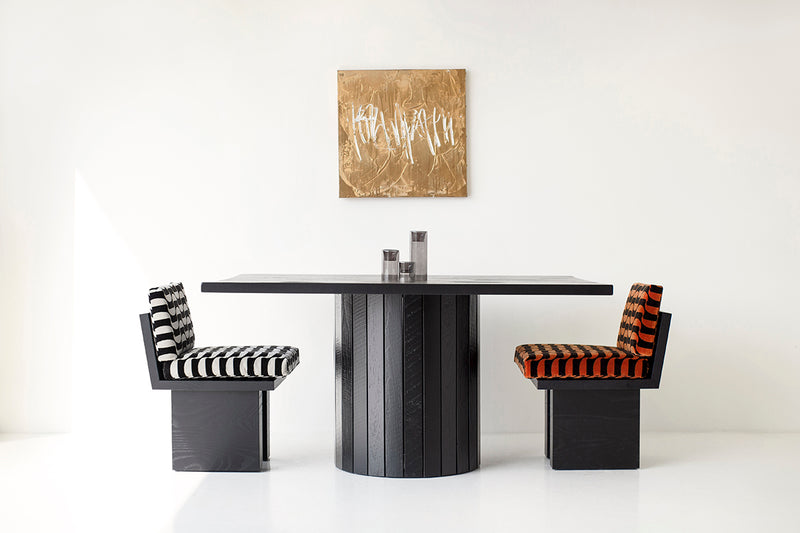 Black reclaimed wood dining table with a drum-shaped slatted base from the Bellhop collection