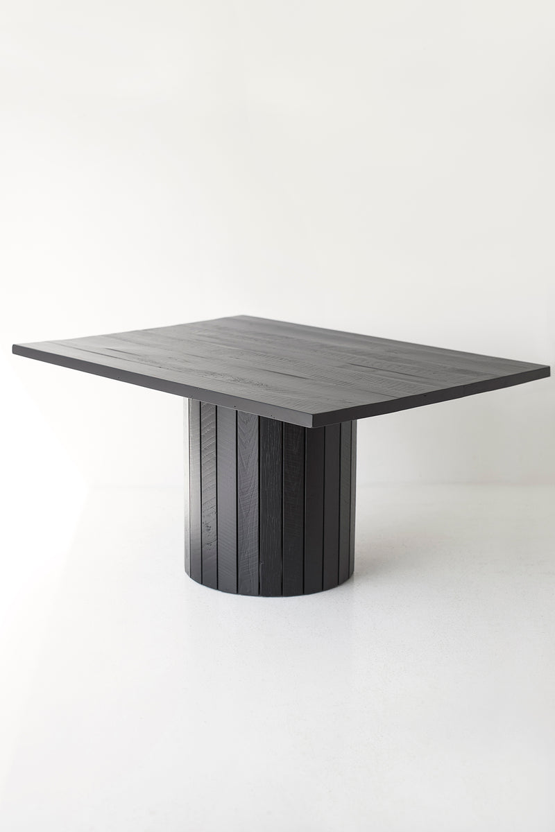 Side angle of a black reclaimed wood table highlighting the slatted drum base