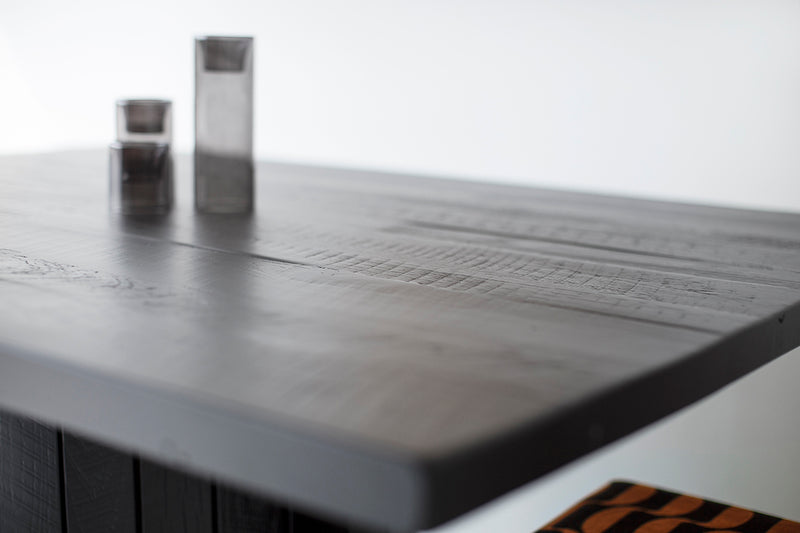 Close-up of the mixed species reclaimed wood grain on a black dining table