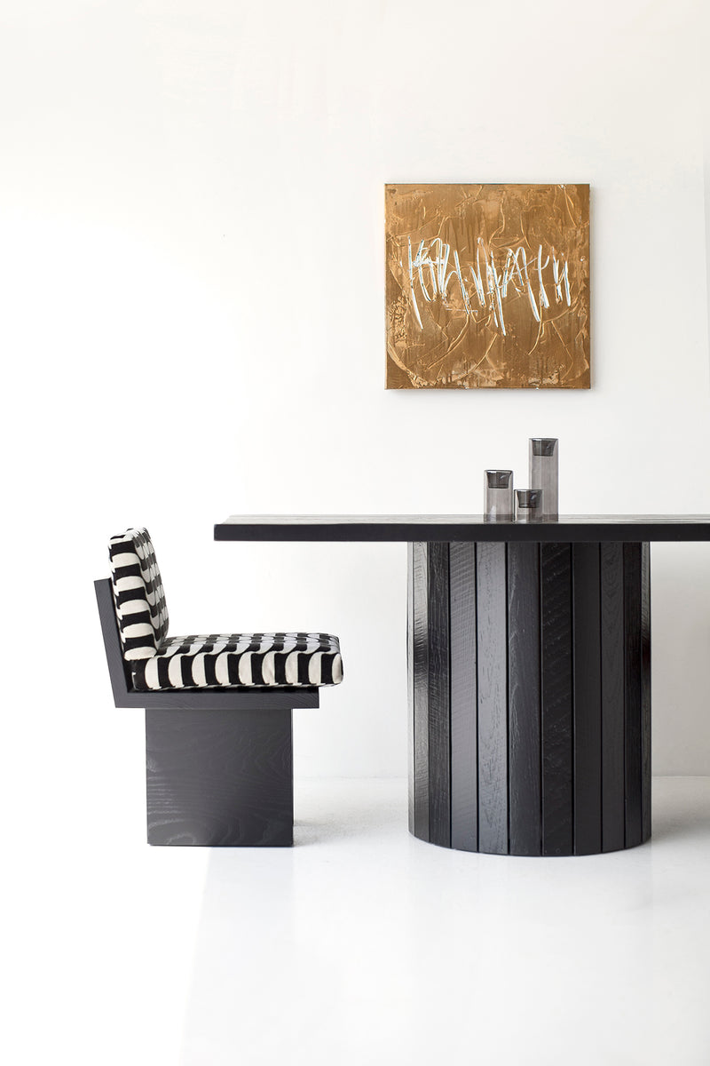 Detail of the drum-shaped slatted base on a reclaimed wood dining table