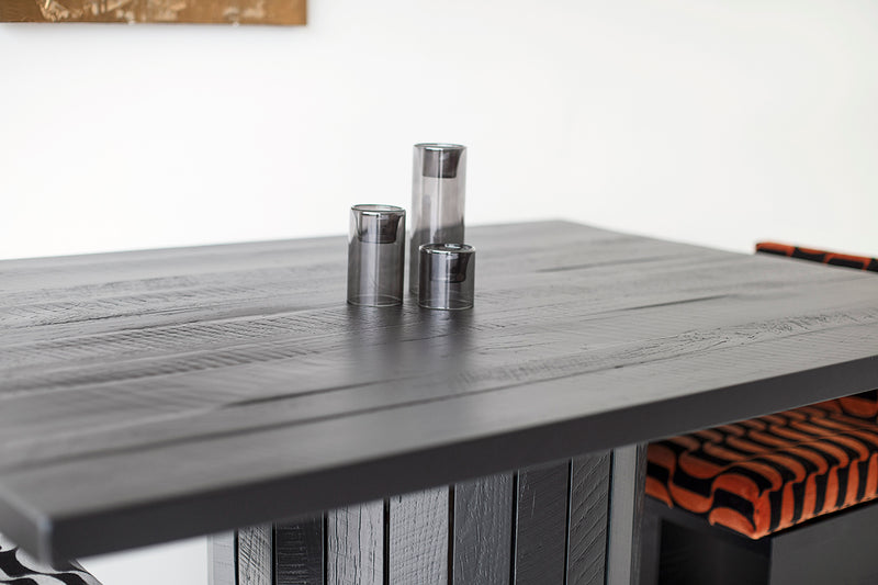Black reclaimed wood dining table styled in a modern dining room