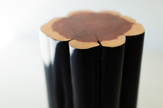 Natural red cedar top on a black outdoor stump table, close view