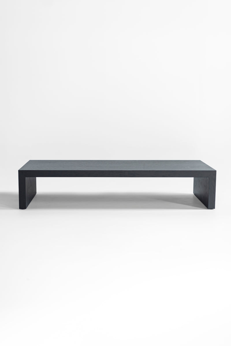 Side profile of a black oak coffee table highlighting its waterfall edge