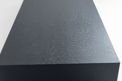 Full view of a blackened oak waterfall coffee table against a white backdrop