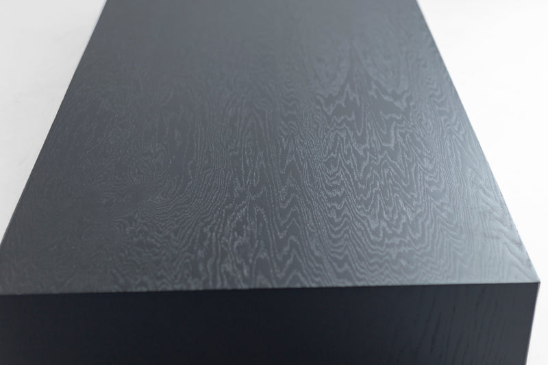 Full view of a blackened oak waterfall coffee table against a white backdrop