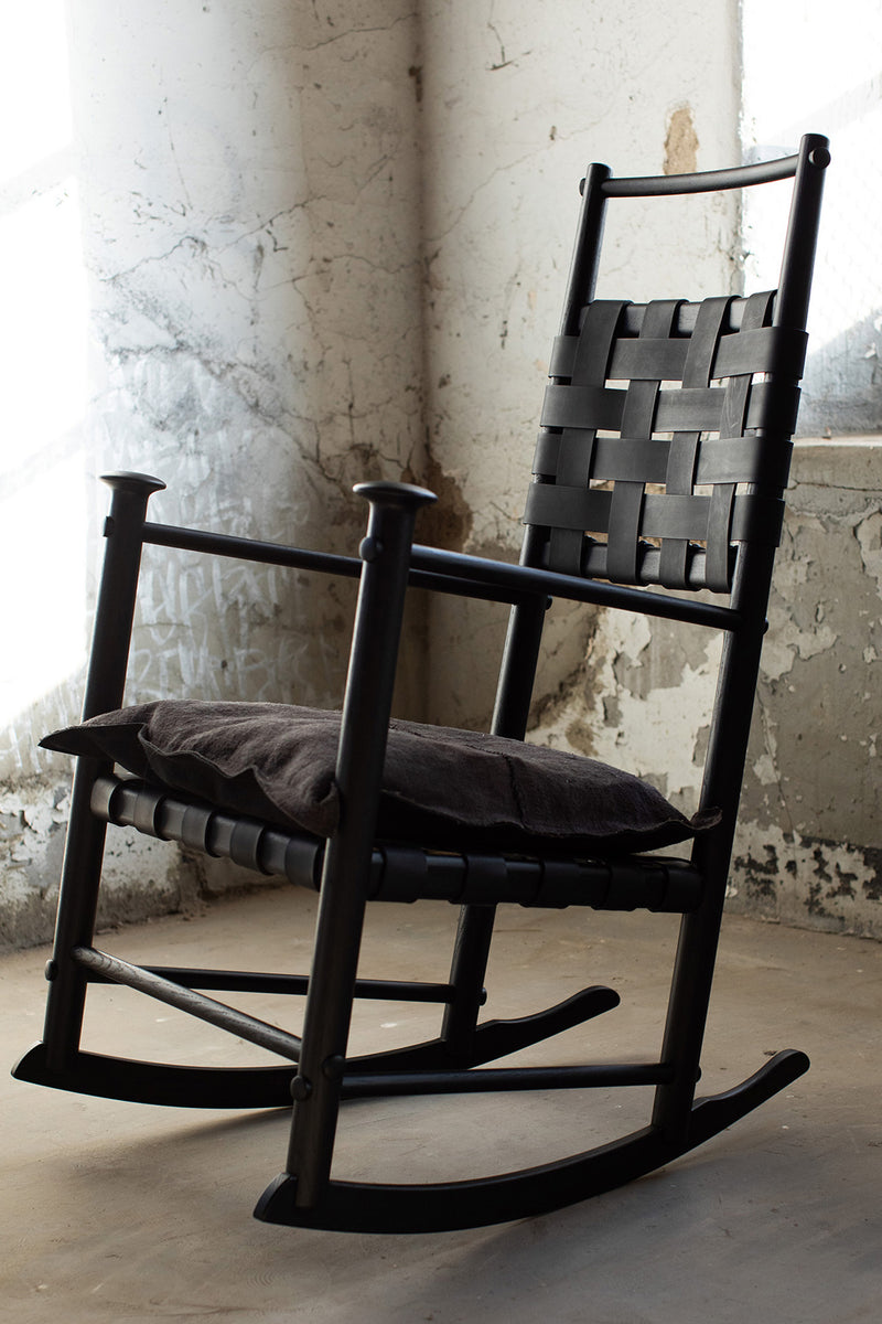 Detail of the hand-shaped matte black oak frame on the modern luxury Catawba rocking chair
