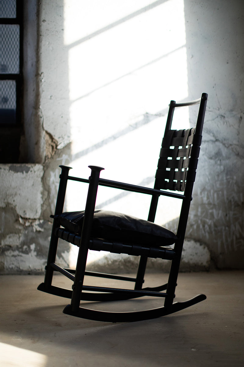 Modern luxury Catawba black leather rocking chair by Craft Associates® styled in a bright interior