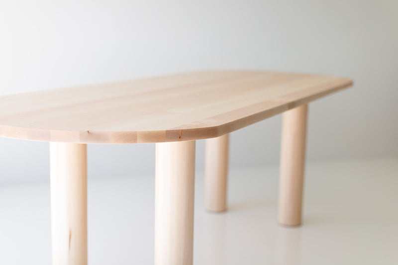 Close-up of the maple wood grain on the Cava oval dining table's surface