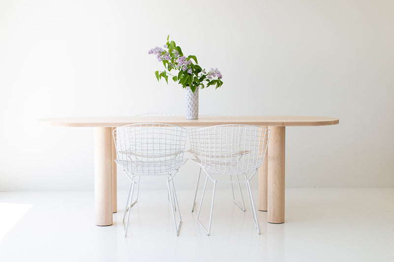 Side profile of the Cava oval dining table showing its chunky leg design