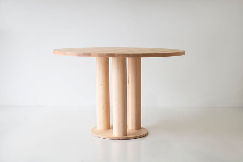 Cava modern round dining table in solid maple with a chunky sculptural pedestal base