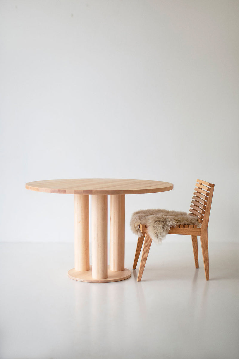 Side profile of the Cava dining table showing its substantial pedestal leg design