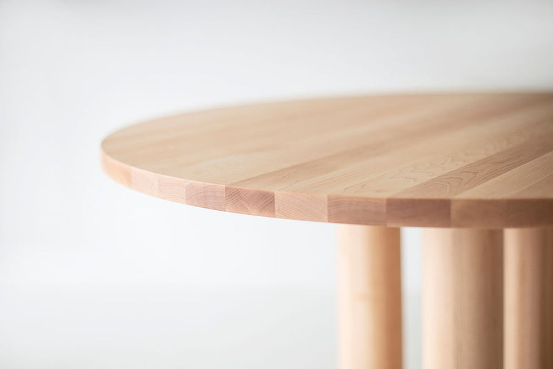Cava round dining table styled with modern dining chairs in a sunlit dining room