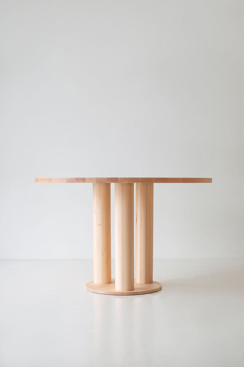 Cava round dining table set for a meal with plates and a centerpiece