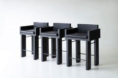 Chunky modern counter stool in blackened oak with a woven fabric cushion