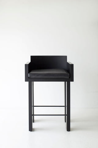 Front view of a blackened oak counter stool showing its cushioned seat