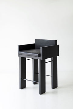 Angled view of a counter stool showing its black commercial grade finish
