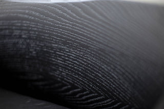 Detail of the oak wood grain and metal joinery on a counter stool