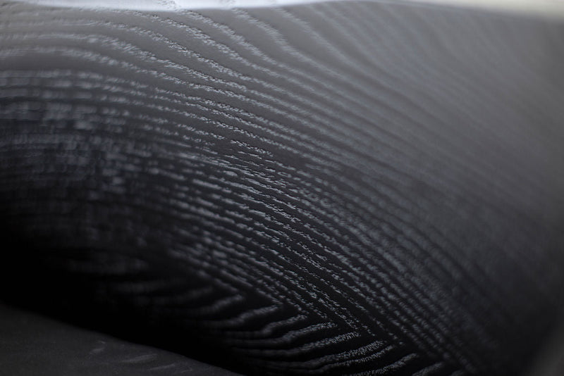 Detail of the oak wood grain and metal joinery on a counter stool