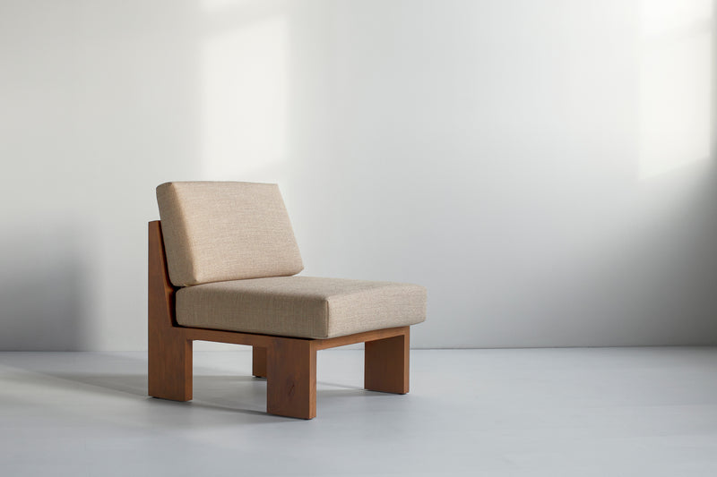Side profile of a greywash lounge chair highlighting its sleek silhouette