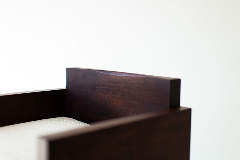 Close-up of the Chile bar stool's cushioned seat and walnut frame