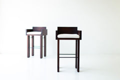 Side profile of the Chile modern bar stool showing its walnut frame and metal rods