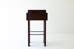 Chile modern bar stool seen at an angle, showing the thick walnut frame and arms