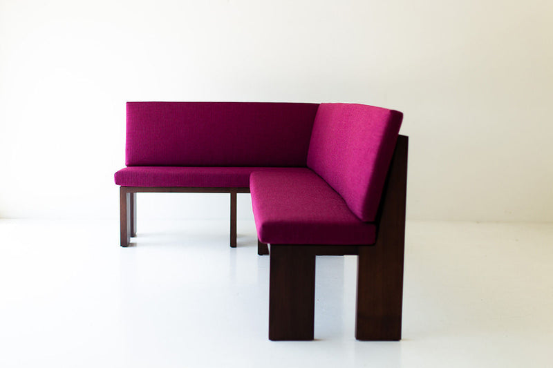 Front view of the walnut banquette with its cushioned seat and back
