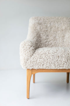 Angled view of the modern luxury Nantucket lounge chair showing its padded shearling seat
