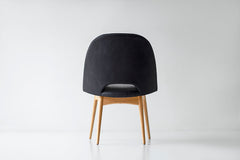 Side profile of an oak side chair highlighting its tall backrest