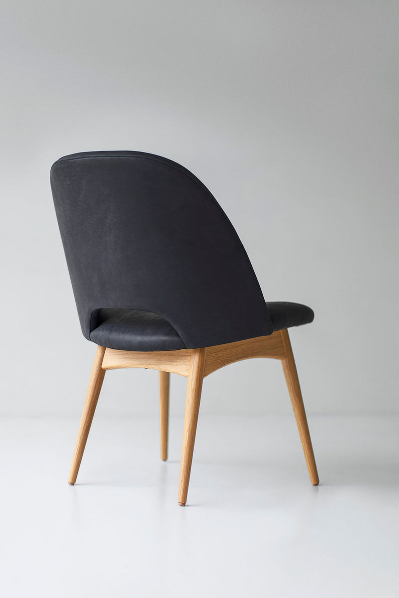 Detail of the oak grain and leather stitching on an executive side chair