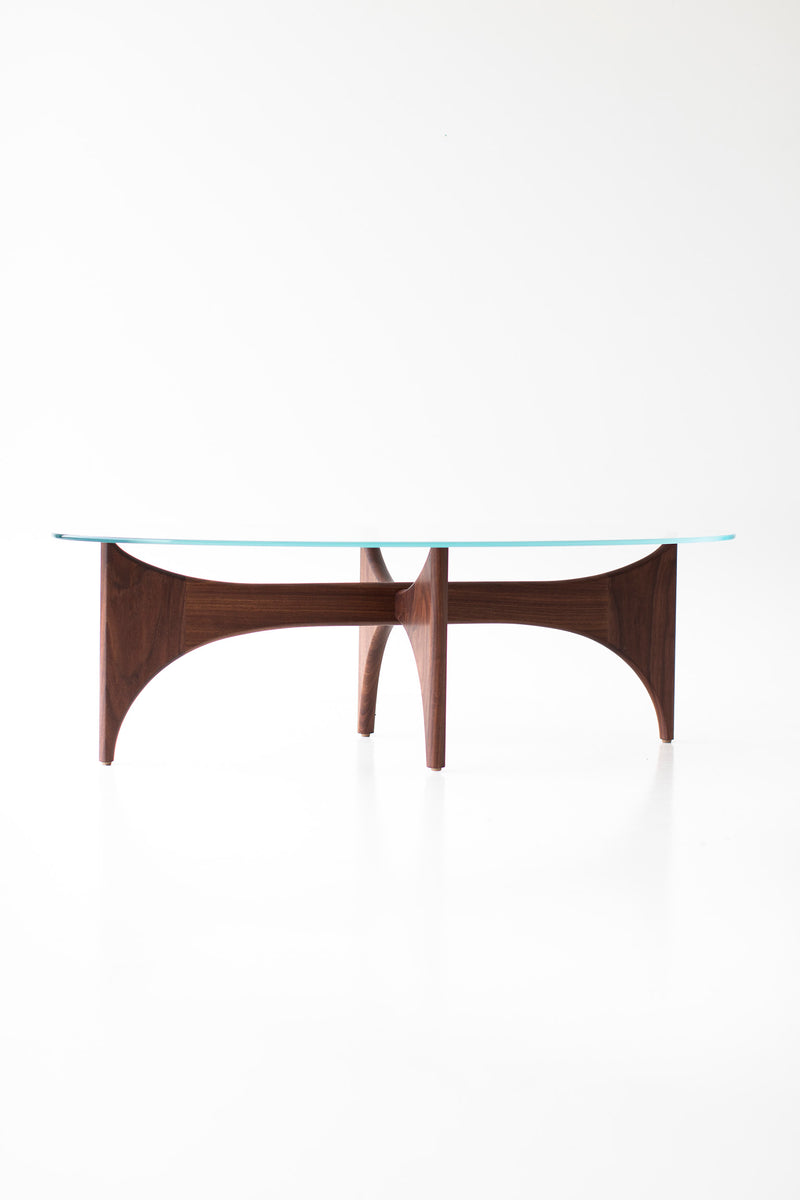 Angled view of the oval glass top coffee table with teak base