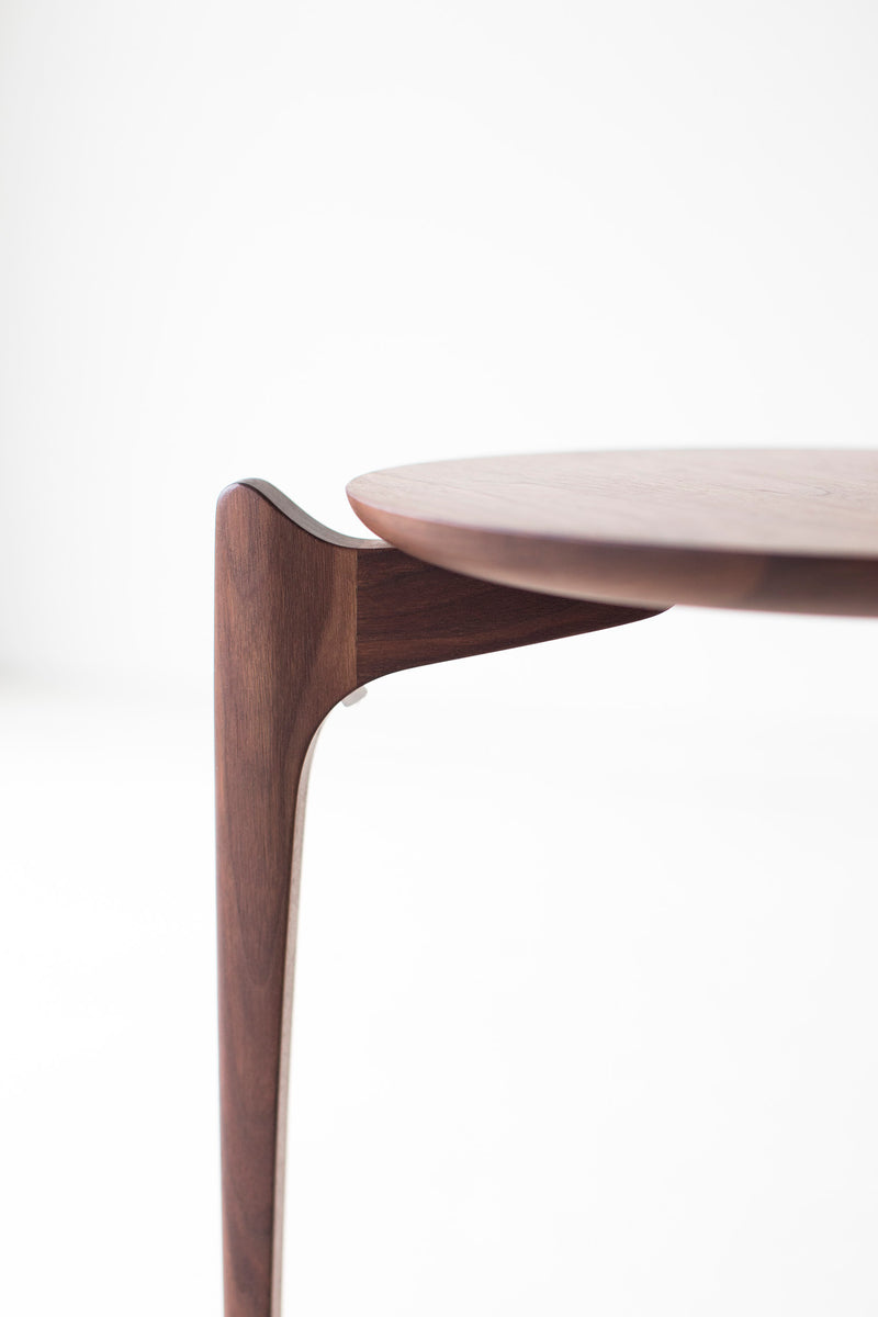 Craft Associates walnut stacking tables shown nested together