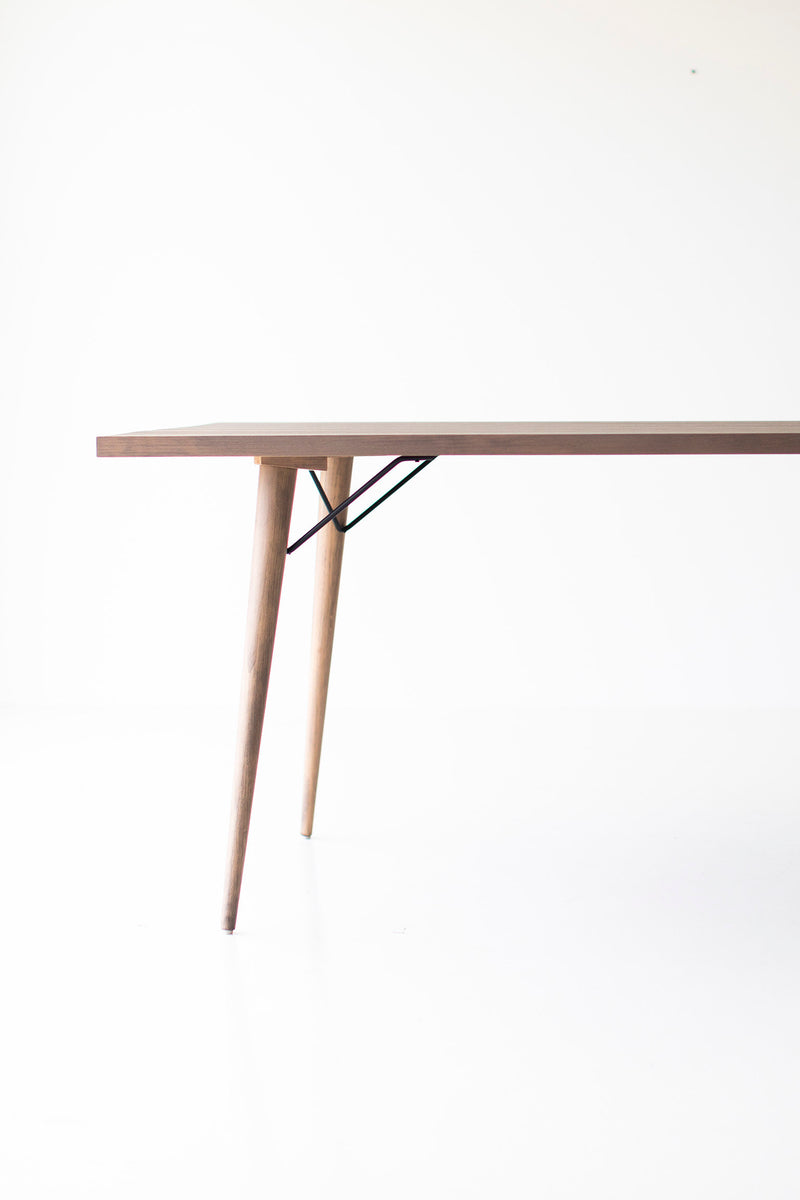 Angled view of the distressed dining table showing its grey-wash finish