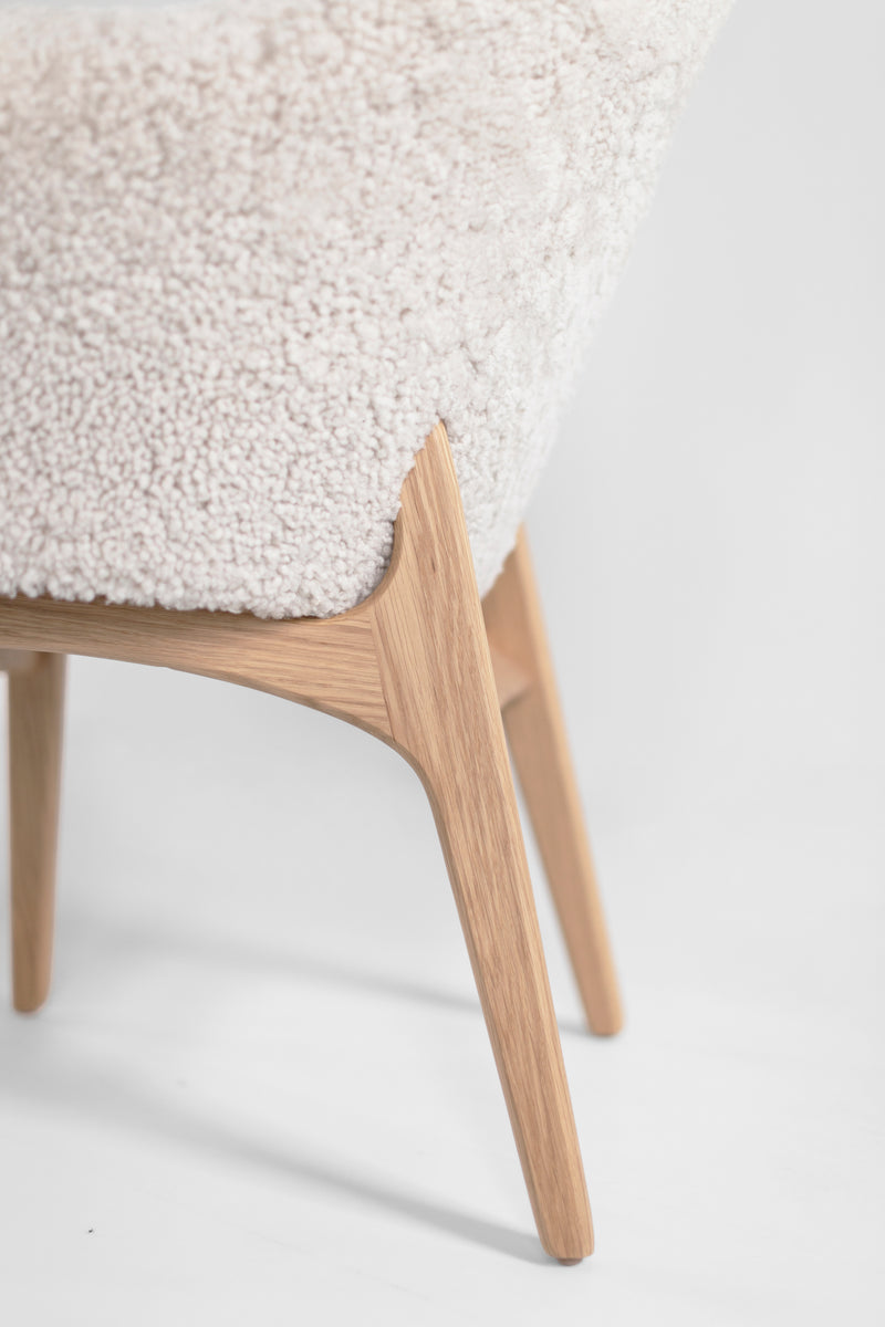 Angled view of an oak dining chair showing its sturdy frame