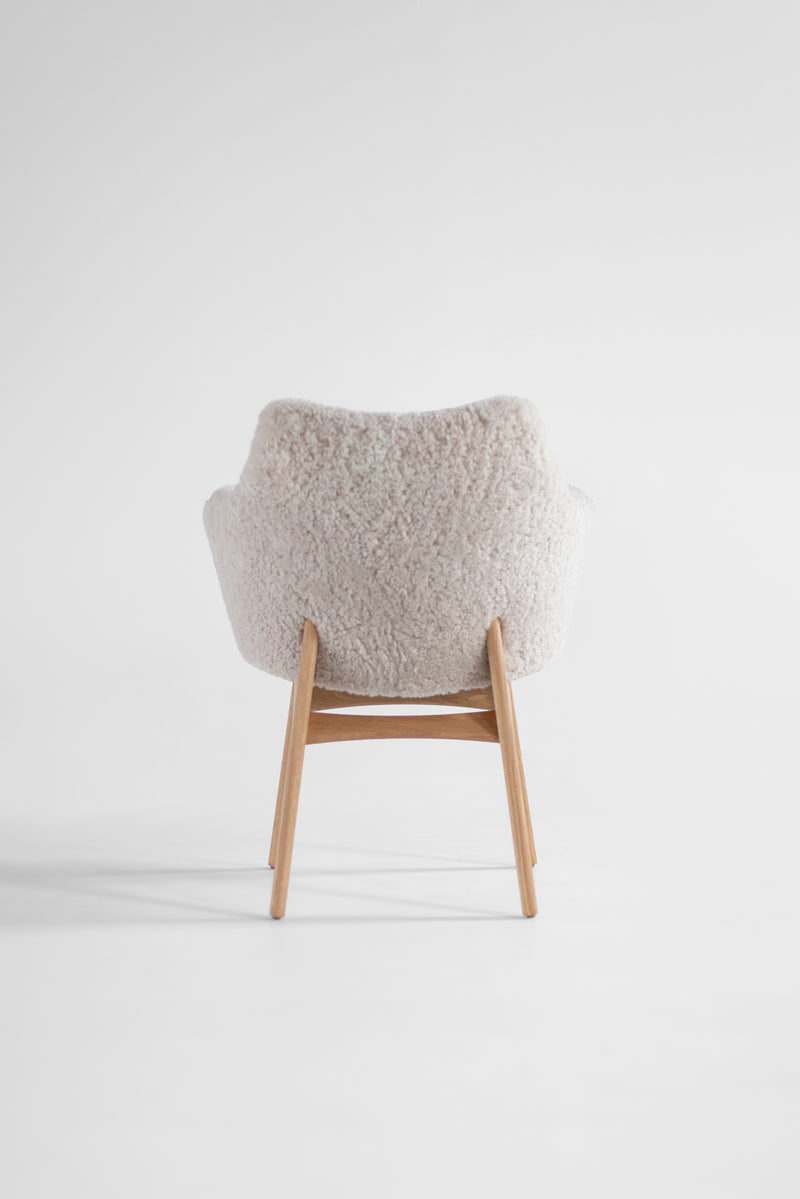 Full view of an executive dining chair in fur against a white backdrop
