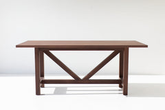 Close-up of the modern walnut farm table legs and base