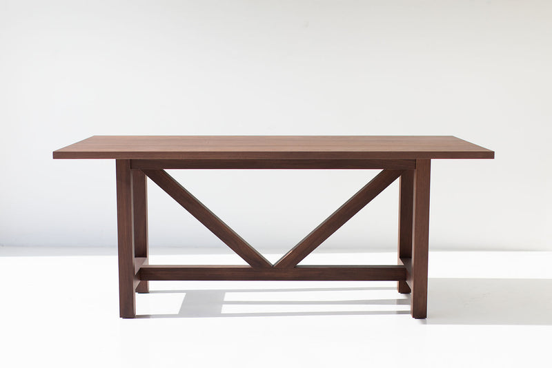 Close-up of the modern walnut farm table legs and base