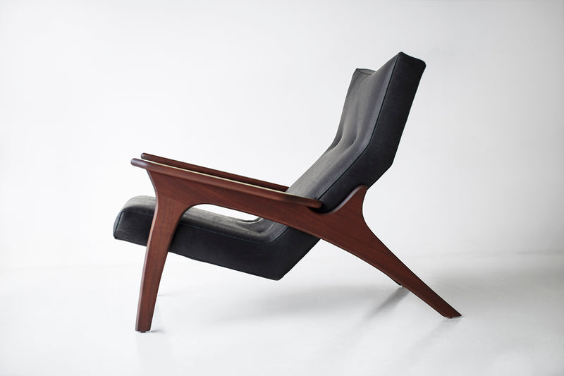 Front view of a walnut leather lounge chair showing its tailored upholstery