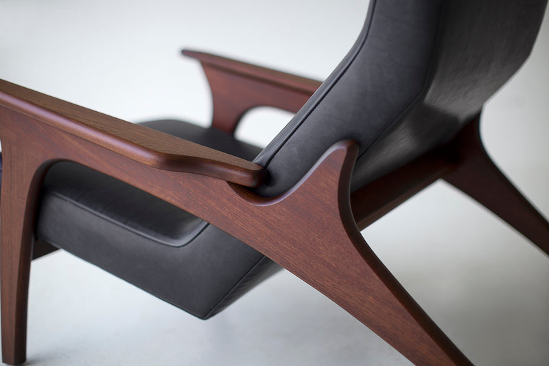 Side profile of the Frank modern leather lounge chair highlighting its walnut frame