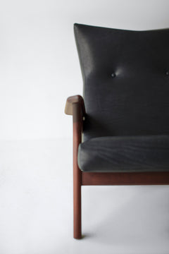 Detail of the walnut oil finish and leg joinery on a leather lounge chair