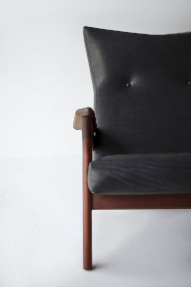 Detail of the walnut oil finish and leg joinery on a leather lounge chair