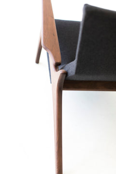 Side profile of the modern Frank wing chair in walnut and upholstered fabric