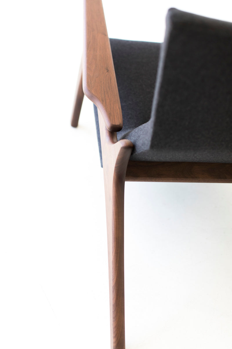 Side profile of the modern Frank wing chair in walnut and upholstered fabric