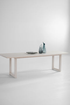 Side profile of a long dining table highlighting its solid wood legs