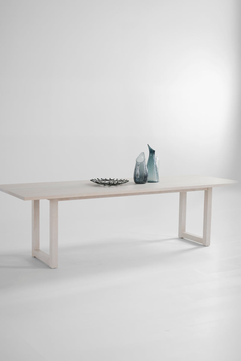 Side profile of a long dining table highlighting its solid wood legs