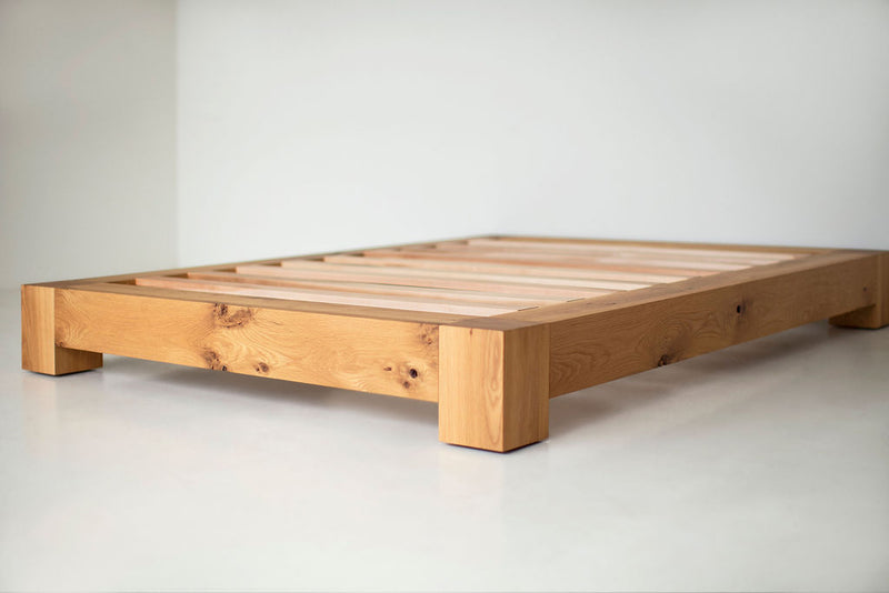 Side profile of a rustic white oak platform bed highlighting its headboard